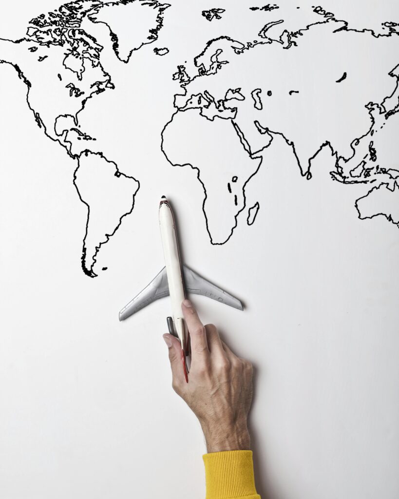 pexels-photo-3754686-3754686 Crop person in vibrant yellow clothes holding little gray plane against contour map on white wall as concept of tourism and adventure
